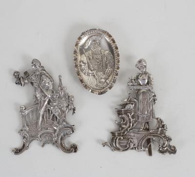A pair of white metal figures,
