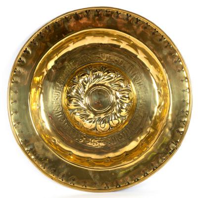 A Nuremberg brass alms dish with embossed