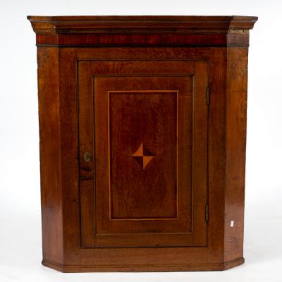 An oak corner cupboard, the panelled