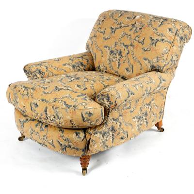 A Howard armchair on turned front legs,