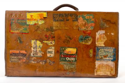 A leather suitcase covered in numerous