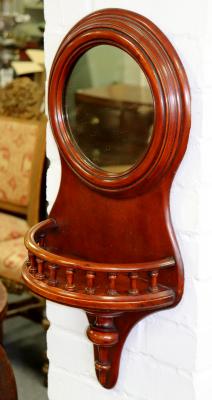A circular wall mirror with galleried