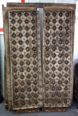 A pair of carved and brass studded doors