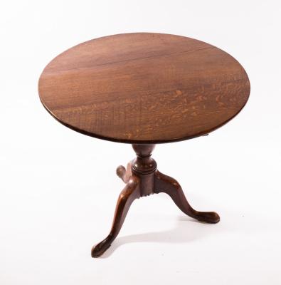 A circular oak tilt-top table,