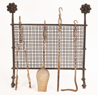 A fire guard with two floral finials,