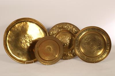 Four embossed brass chargers of