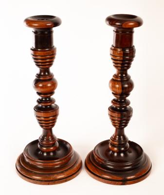 A pair of turned lignum vitae candlesticks,