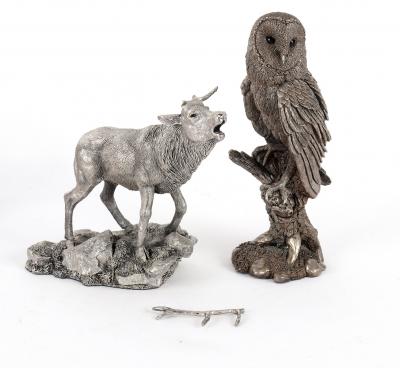 A filled silver model of an owl