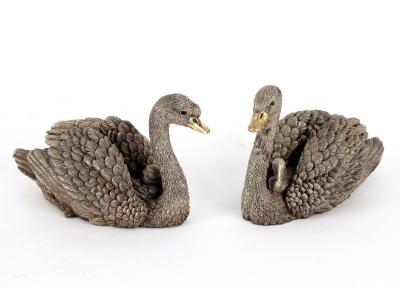 A filled silver model of a pair of swans,