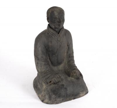 A black pottery figure of a seated Chinaman