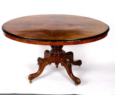 A Victorian walnut oval table with ebonised