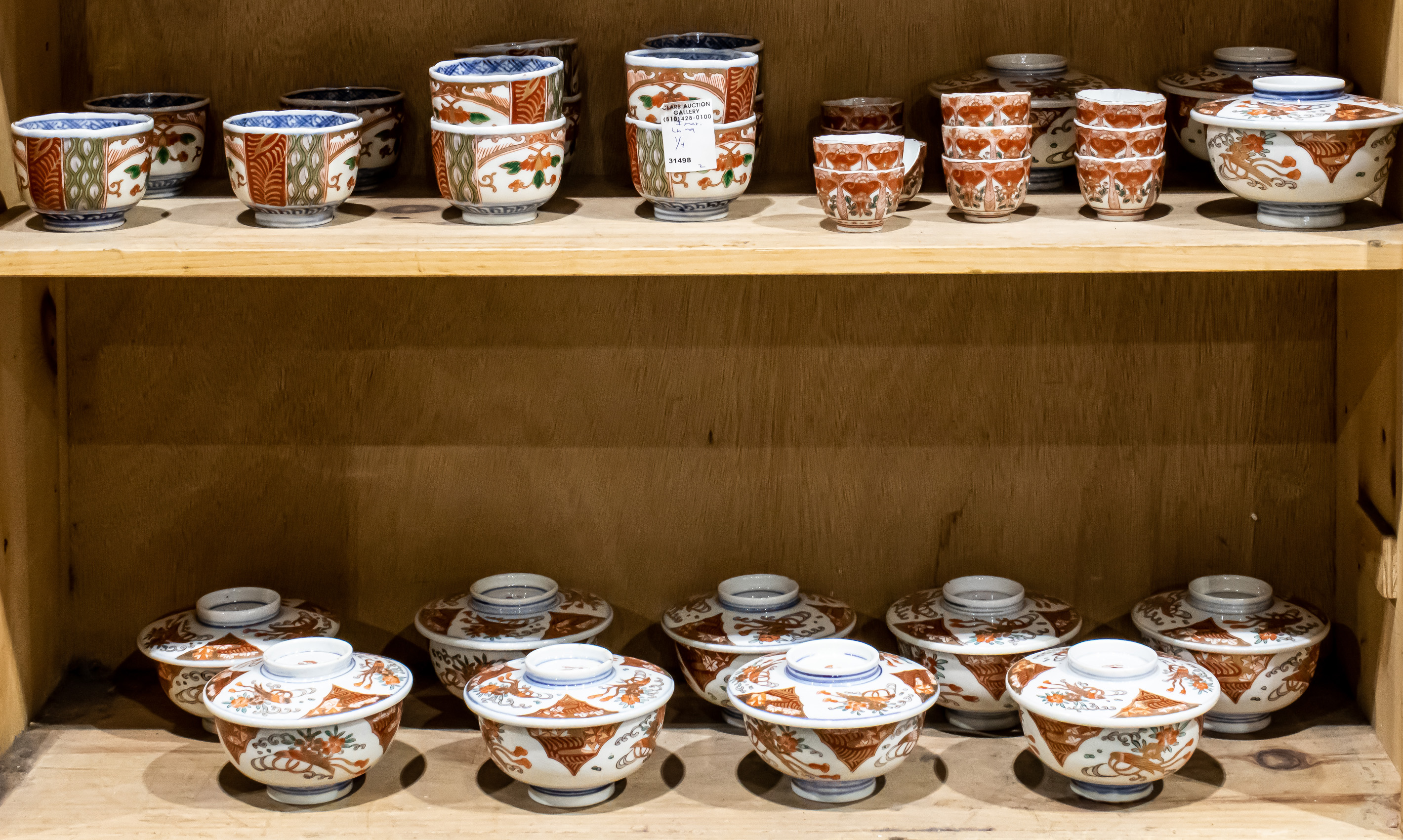 TWO SHELVES OF JAPANESE IMARI CUPS AND