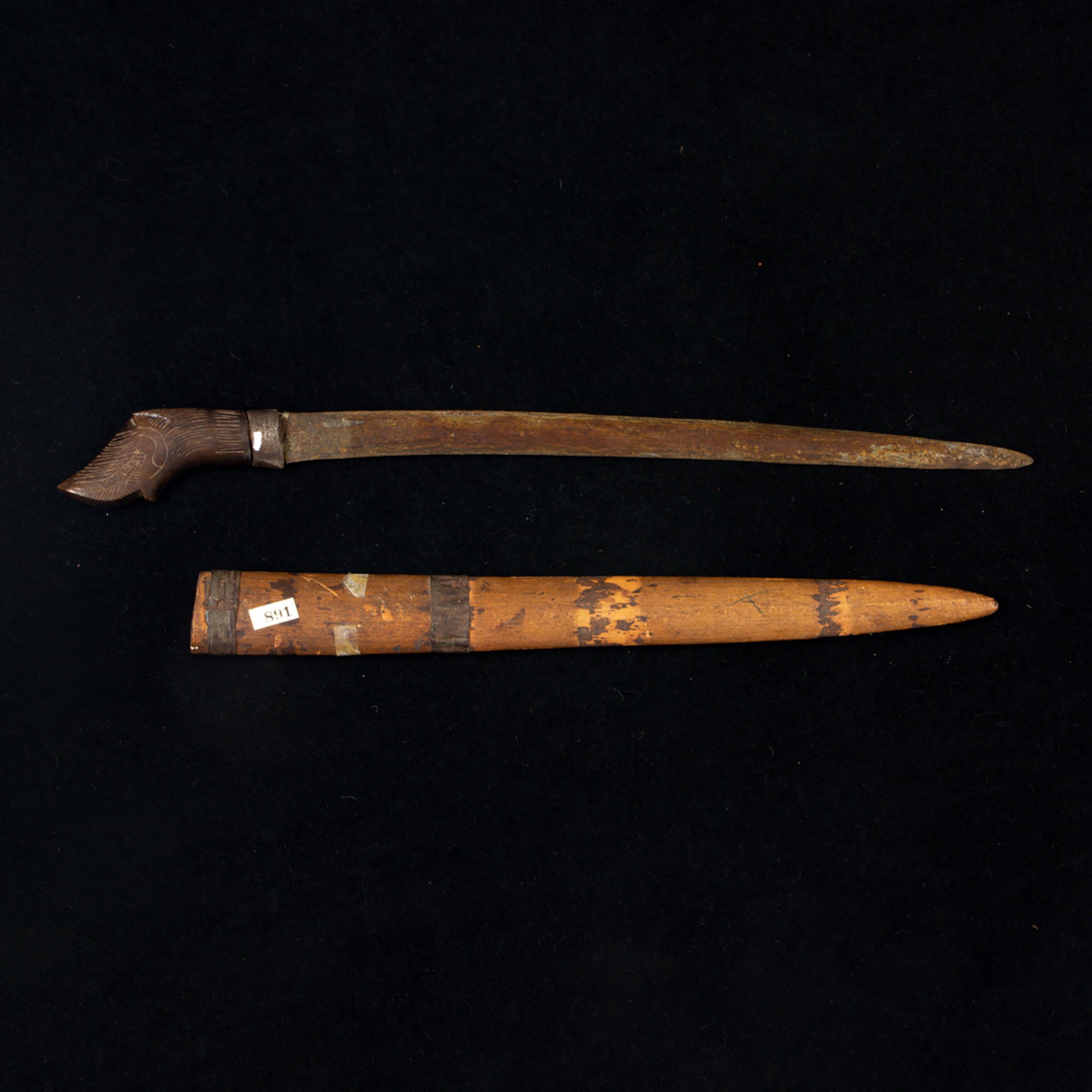A PRIMITIVE SWORD WITH A CARVED