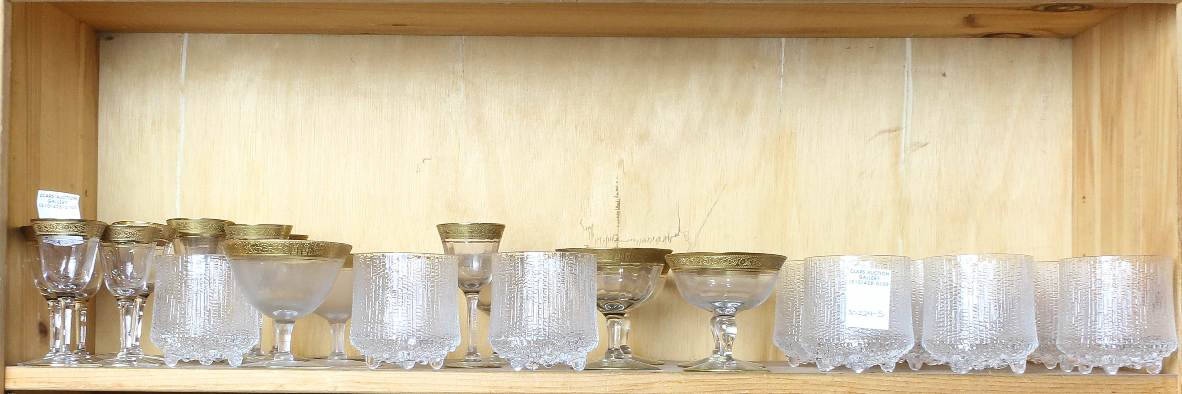 SHELF OF GILT RIMMED STEMWARE AND