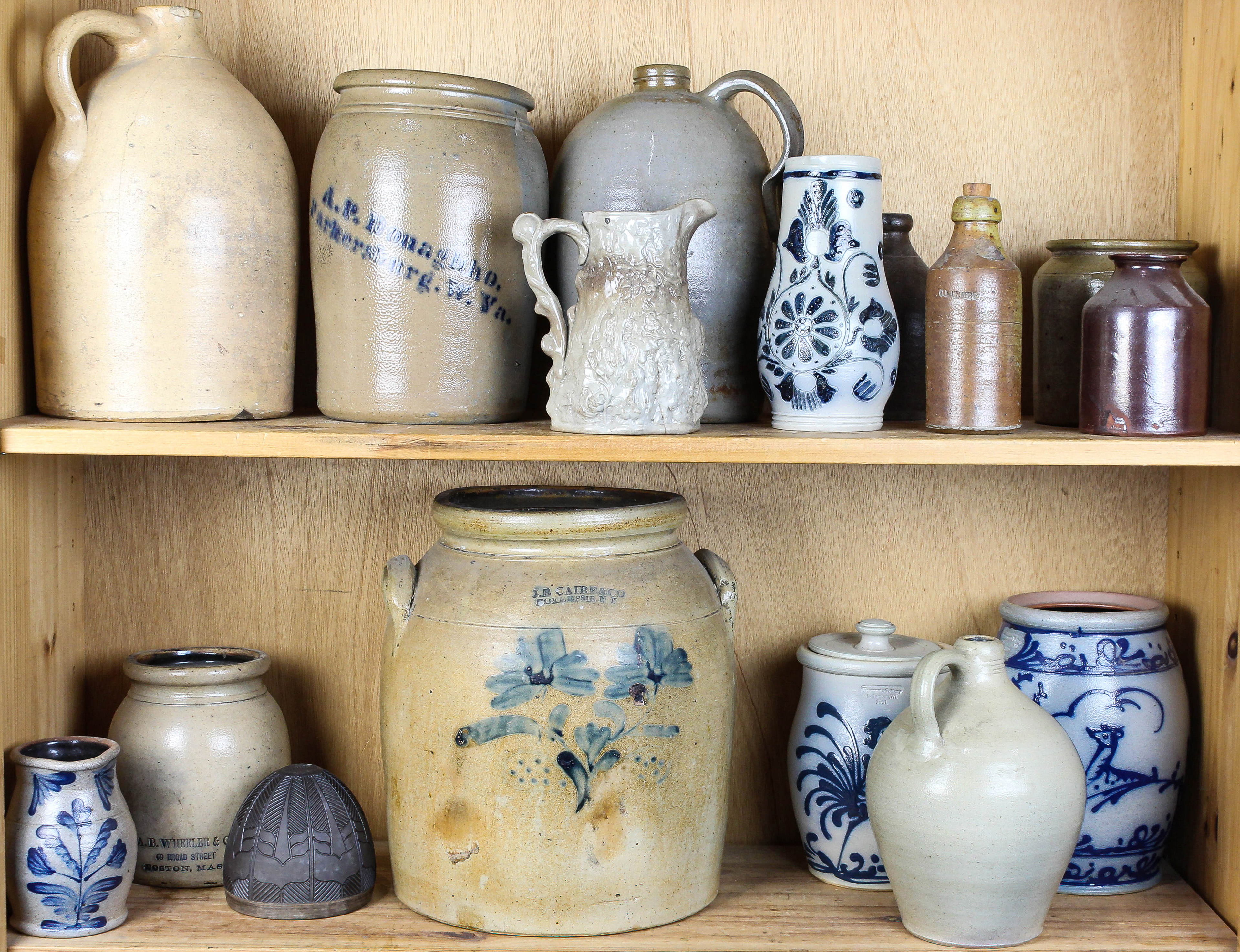 TWO SHELVES OF STONEWARE JARS AND