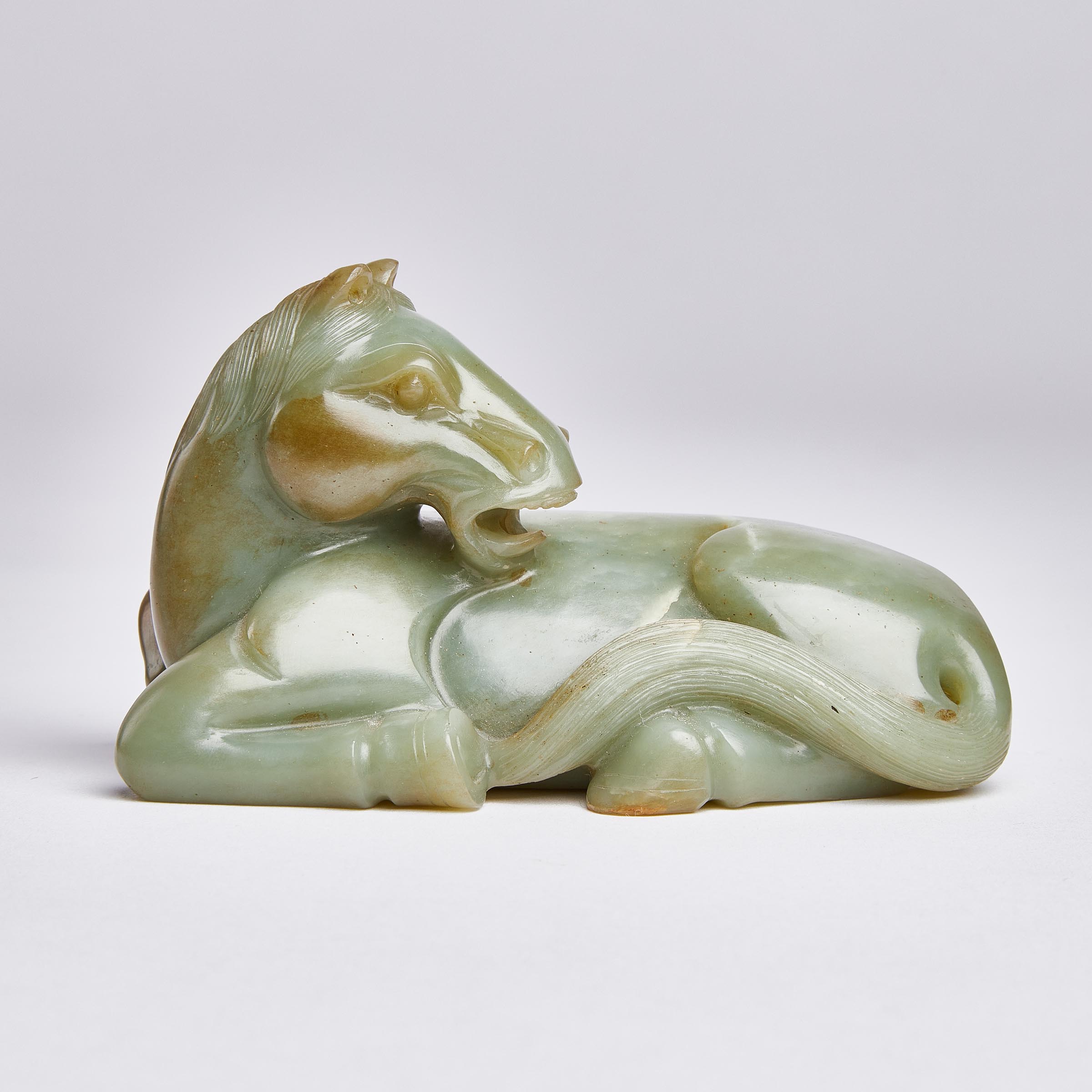 A Celadon Jade Figure of a Recumbent