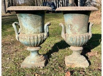 A pair of small antique iron urns