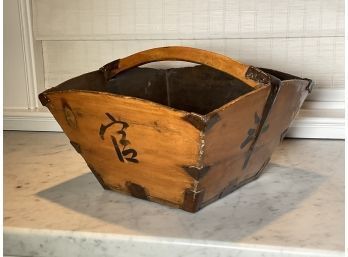 A vintage Asian wood basket with a wood