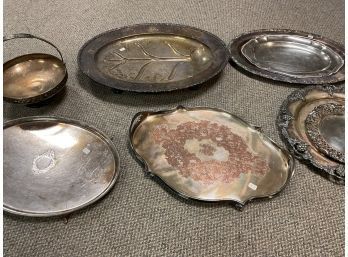 Seven silver plated trays and one basket,