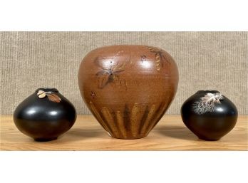 A pair of black glazed pots with