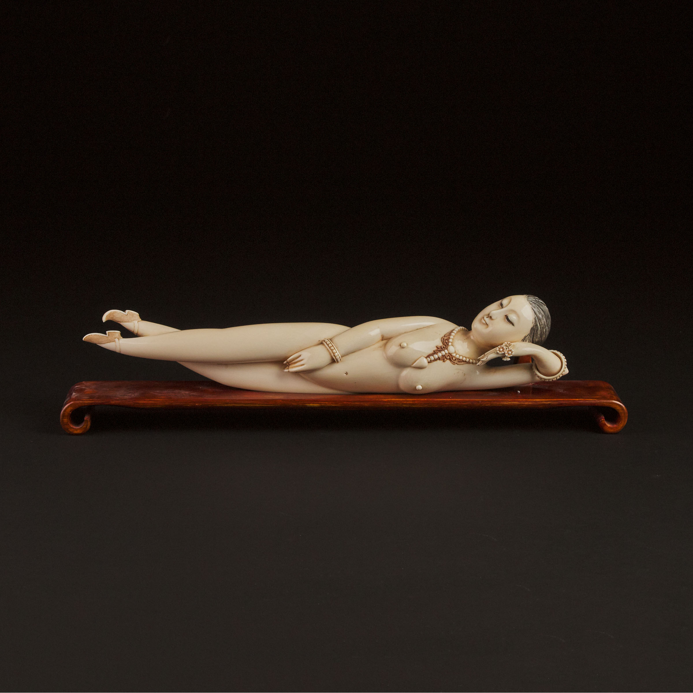 A Large Ivory Figure of a Reclining