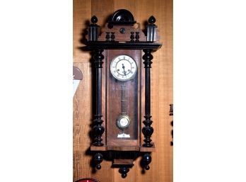 An antique wall clock with walnut case,