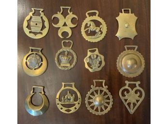 Twelve brass horse tack decorations.