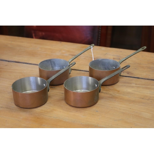 Four small scale copper pots, brass