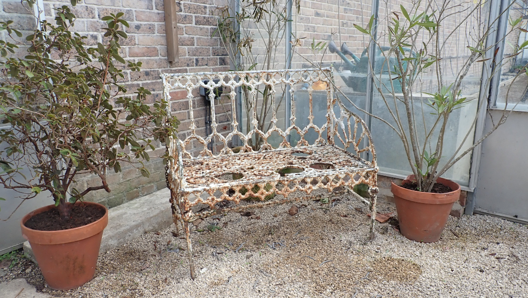 A WHITE PAINTED GARDEN BENCH OF