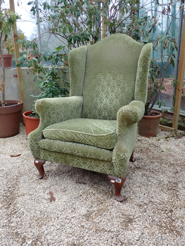 A 1920S WING ARMCHAIR upholstered