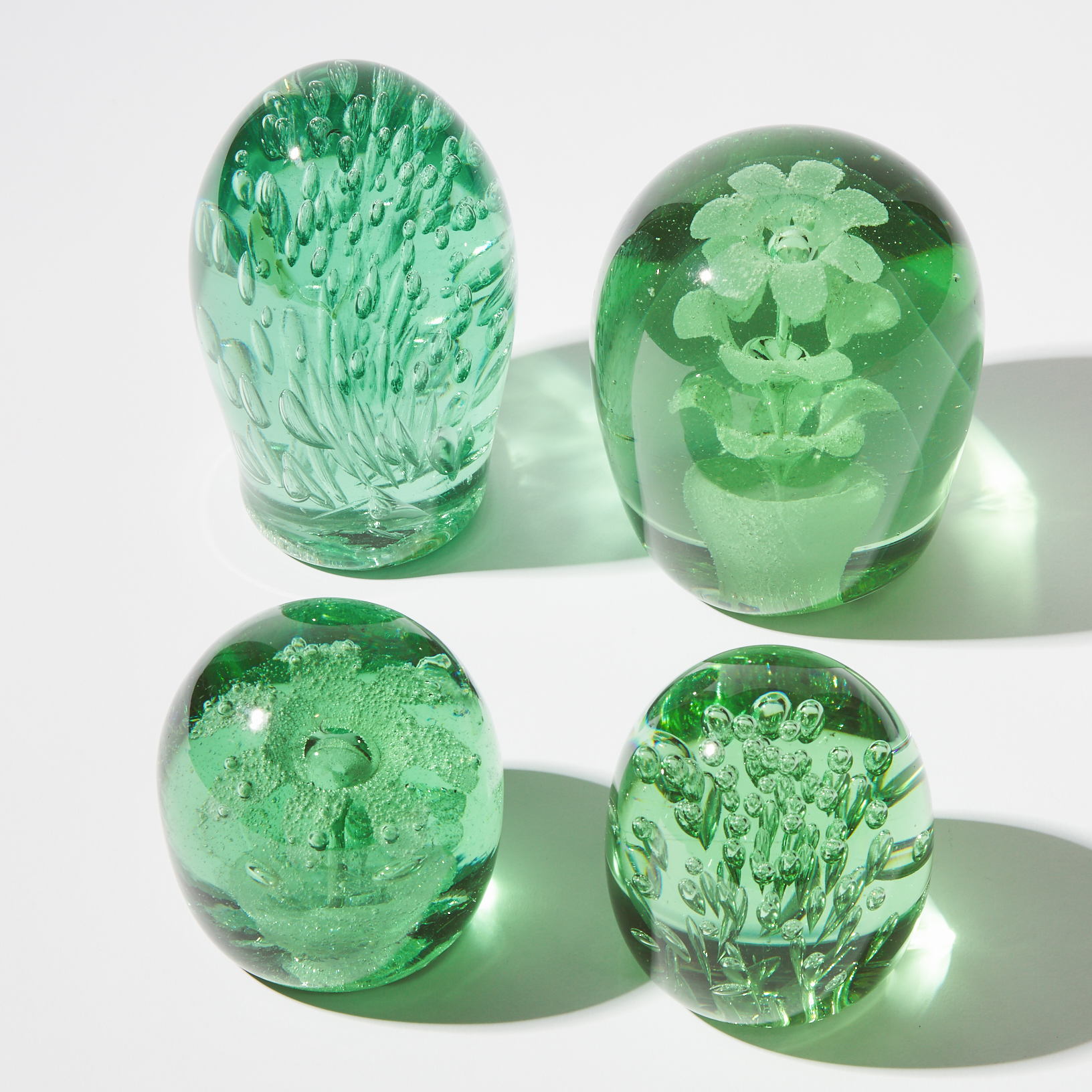 Four Green Bottle Glass Dump Paperweights,