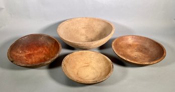 Four antique wood chopping bowls.