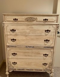 A modern five drawer chest with ornate