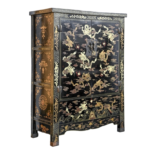A Chinese black and gold lacquer wardrobe,