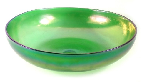 An iridescent green glass bowl, possibly