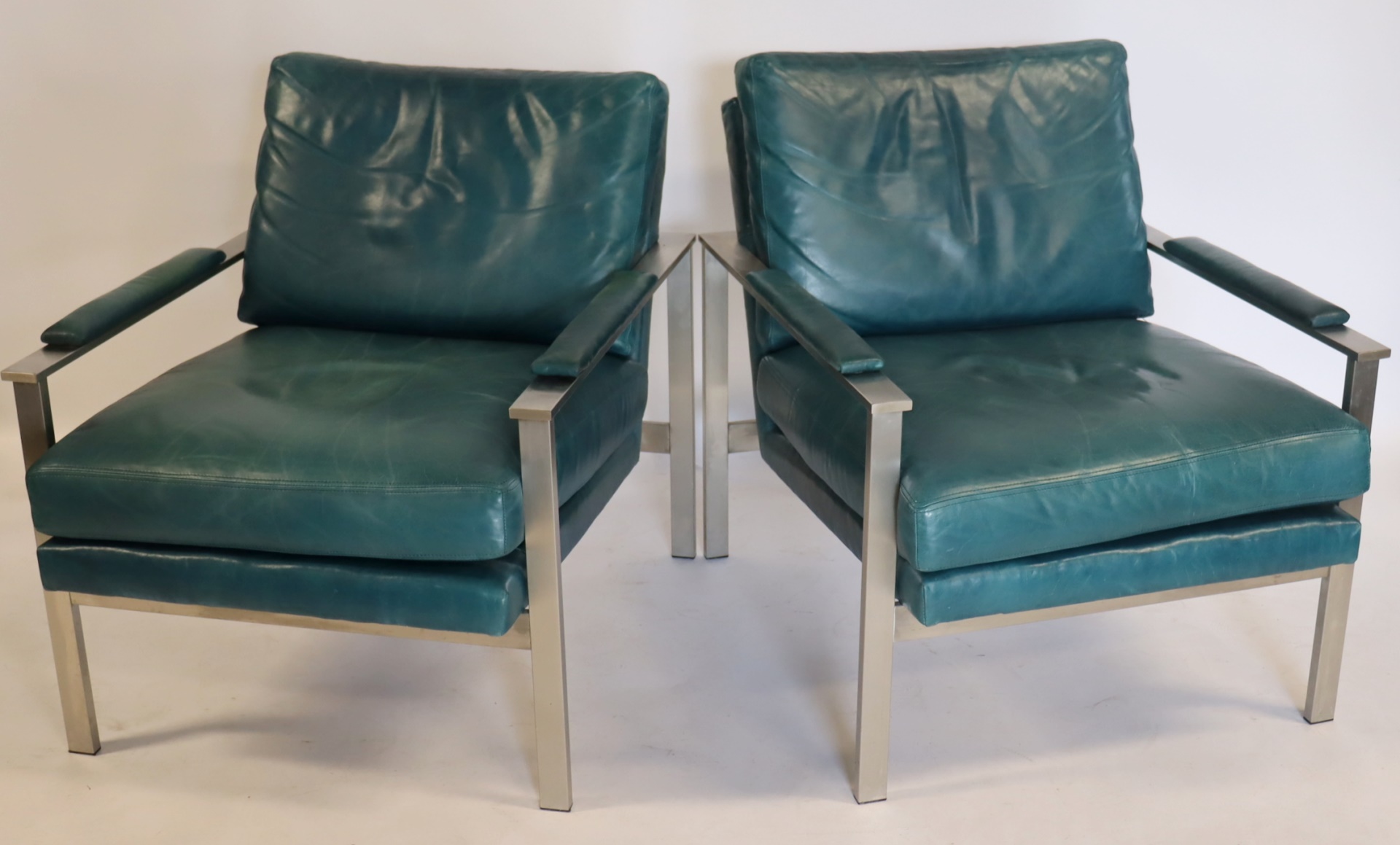 A PAIR OF MIDCENTURY STYLE LOUNGE CHAIRS.