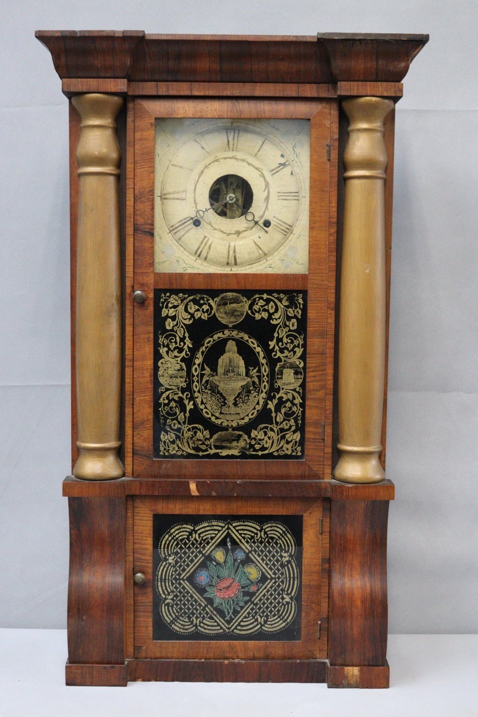 AN ANTIQUE WOOD CASED CLOCK WITH