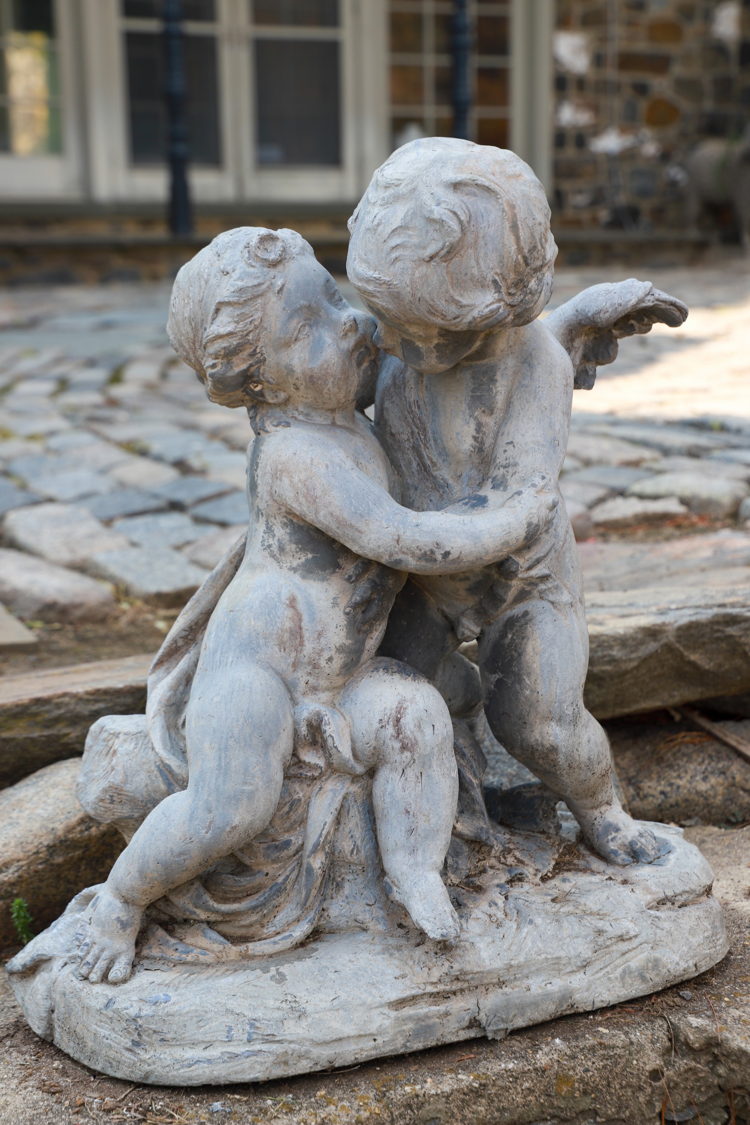 Garden statue of cherub holding putti,