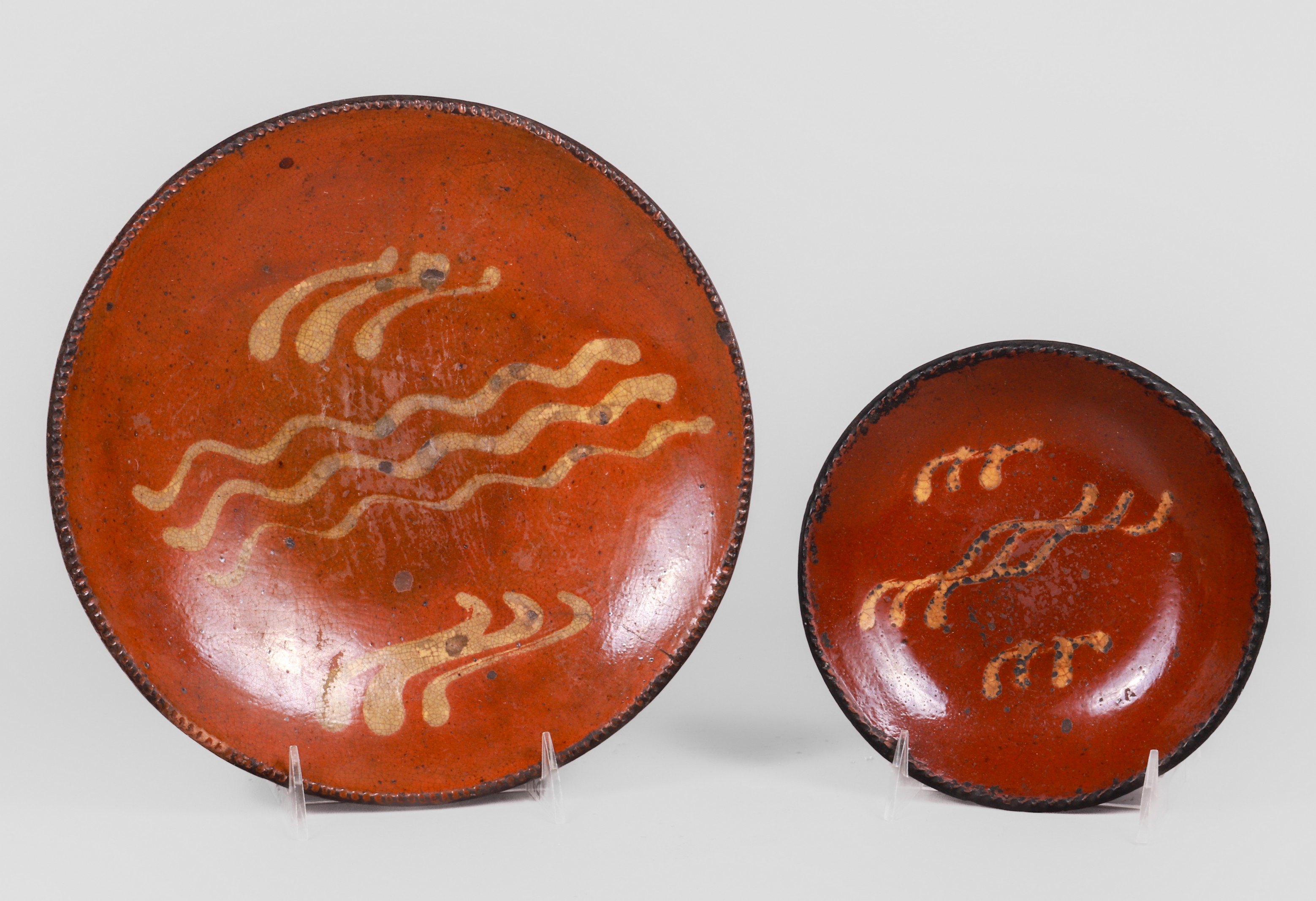 (2) Redware dishes in yellow slip decoration,