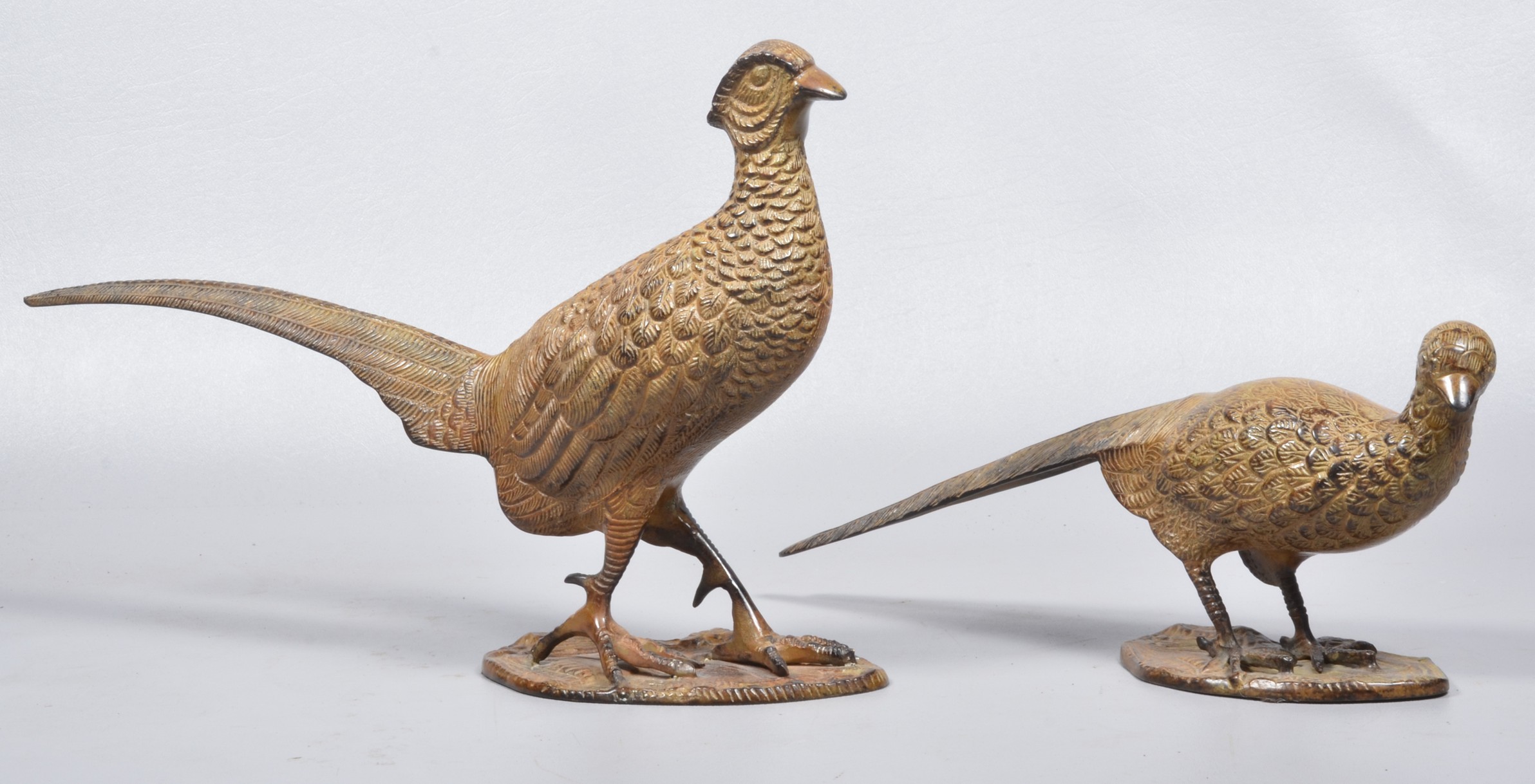 A pair of brass patinated pheasant sculptures,