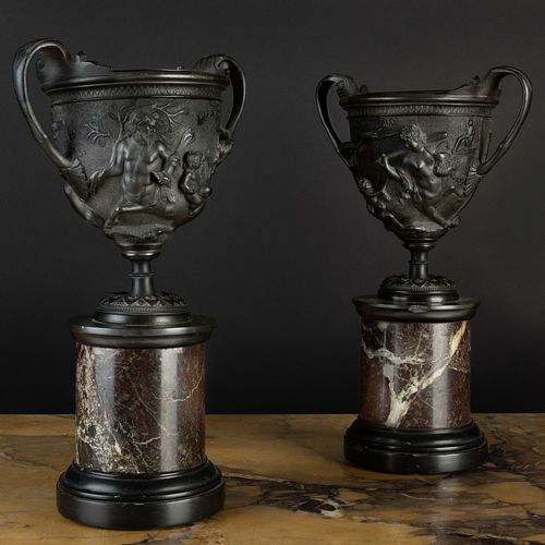 PAIR OF TWO-HANDLED BRONZE URNS ON MARBLE