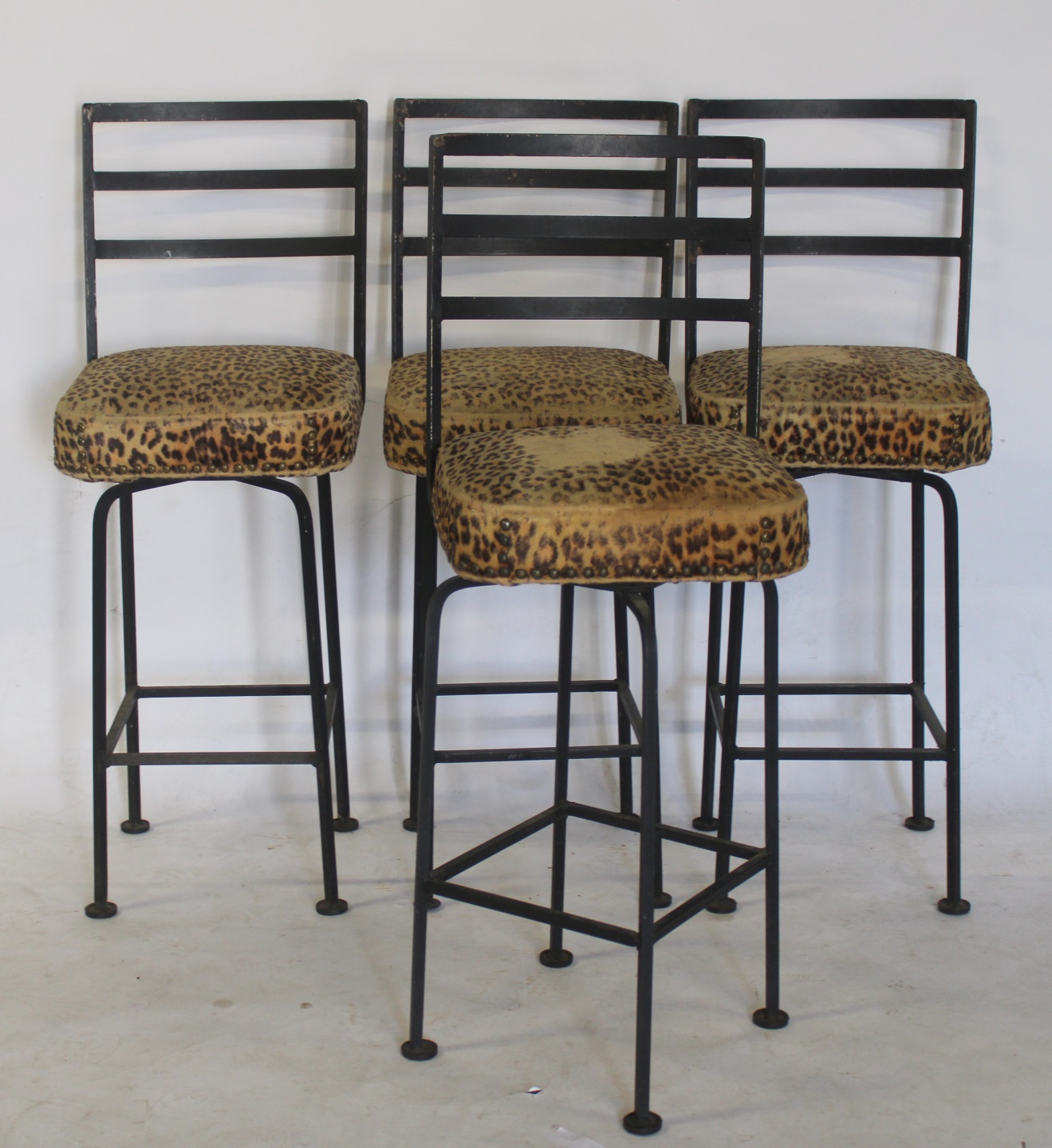 4 MIDCENTURY PATINATED METAL STOOLS.