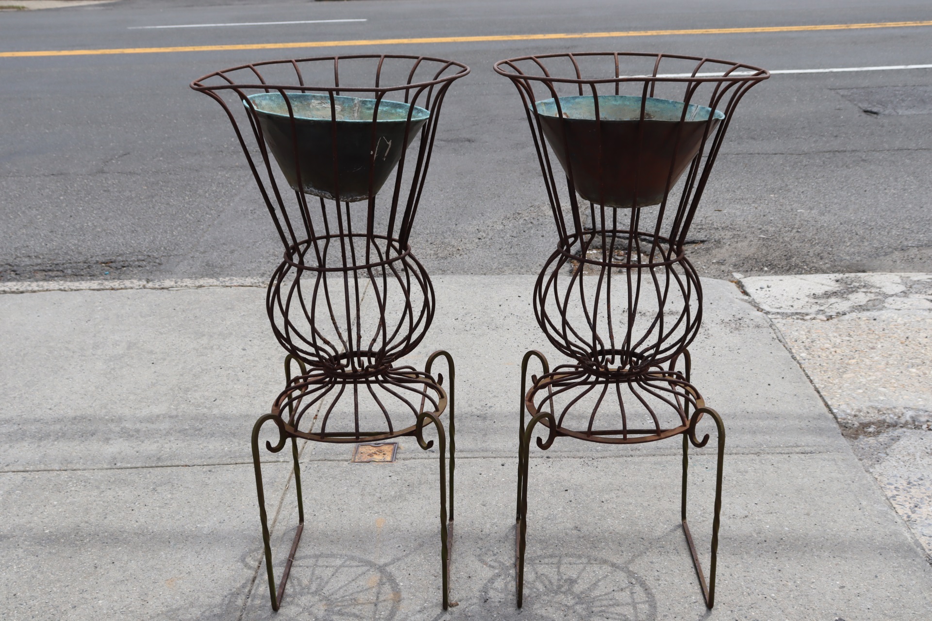 AN ANTIQUE PAIR OF IRON PLANTERS