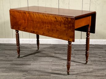 An antique cherry drop leaf table, with