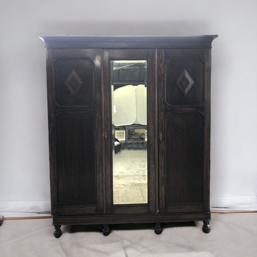 CARVED DARK OAK TRIPLE WARDROBE.