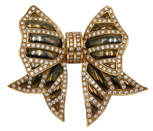 18 KARAT GOLD BOW BROOCH, HAVING