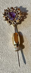A 14k gold pin, set with a heart