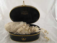 A barrister's wig in oval tin box.