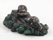 A bronzed figure of an infant