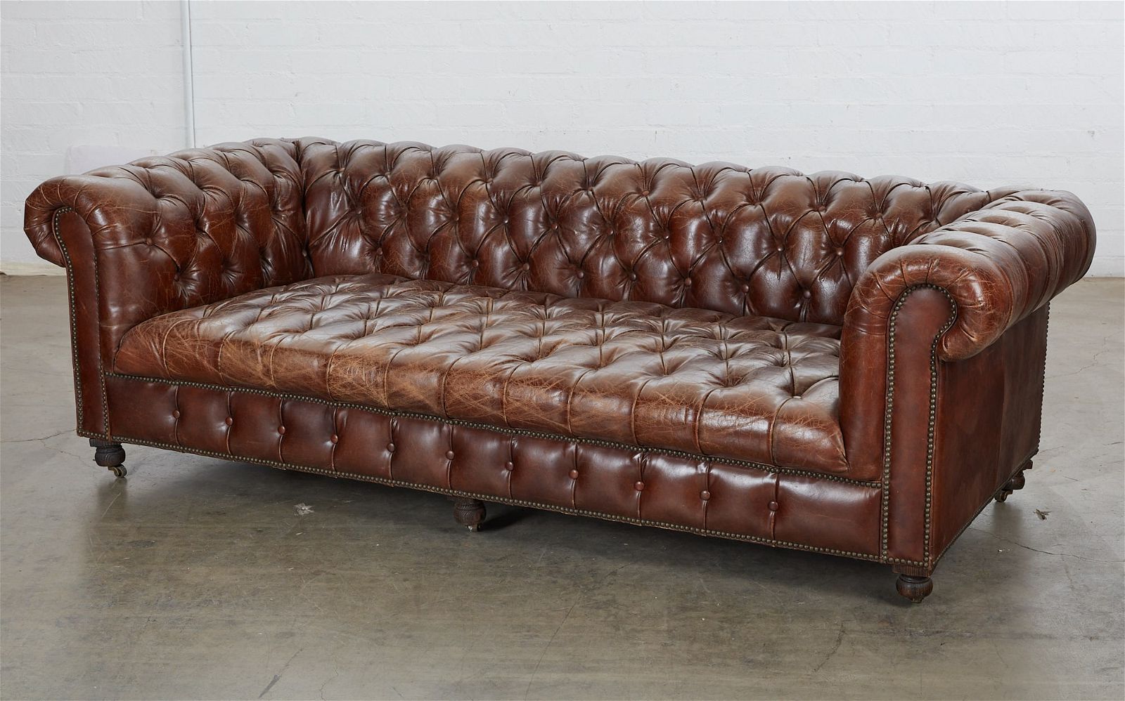 A BROWN LEATHER TUFTED CHESTERFIELD
